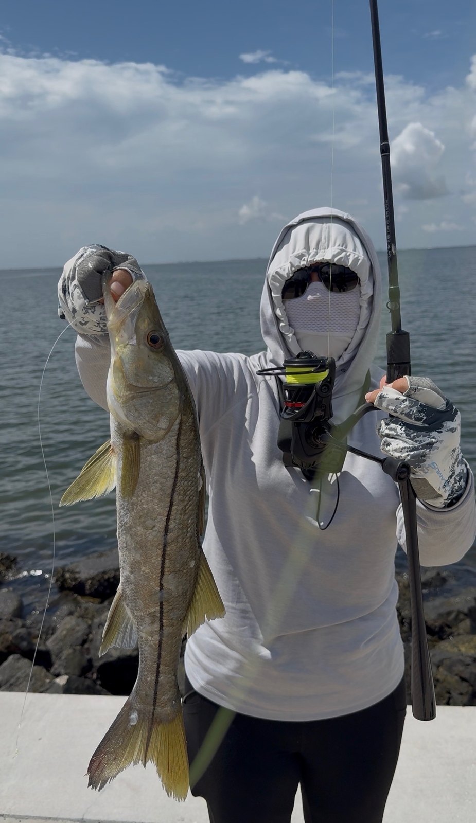 Snook held up at the water's edge